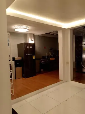 a living room with a black refrigerator and a kitchen at Montalban Villa in General Trias