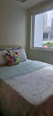 a bedroom with a large bed with a window at SM JAZZ RESIDENCES-Urban Escape in Manila