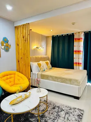 a bedroom with a bed and a couch and a table at Peaceful and cozy unit in Manila