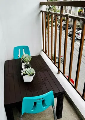 a table and chairs on a balcony with a table and plants at Peaceful and cozy unit in Manila