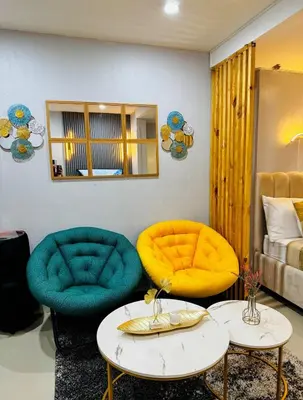 a room with two chairs and a bed at Peaceful and cozy unit in Manila