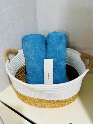 a basket with two blue pillows on a table at Peaceful and cozy unit in Manila