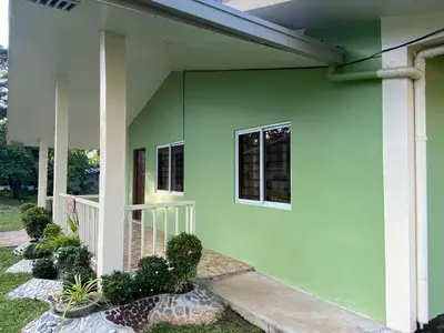 a green house with two windows and some plants at Home of Joy Villa Peace House in Dasmariñas