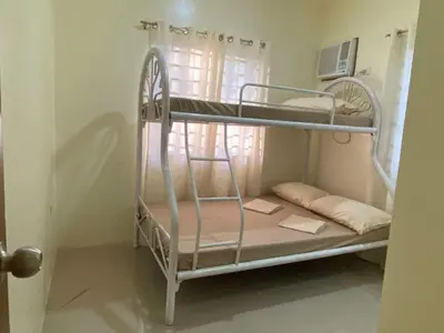 a bunk bed in a room with a window at Home of Joy Villa Peace House in Dasmariñas
