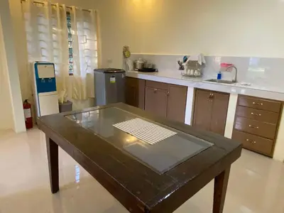 a kitchen with a table in the middle of it at Home of Joy Villa Peace House in Dasmariñas