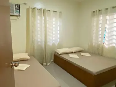 a small room with a bed and a window at Home of Joy Villa Peace House in Dasmariñas