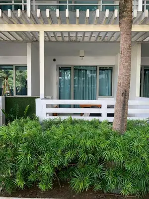 a white bench in front of a house with a tree at Azure Urban Resort - Rio Tower in Manila