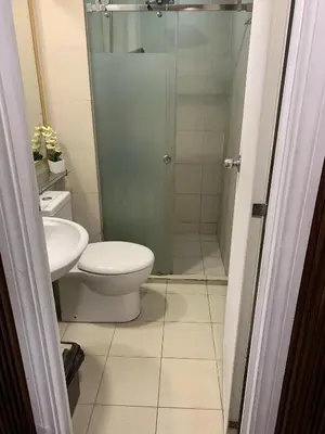 a bathroom with a toilet and a glass shower at Azure Urban Resort - Rio Tower in Manila