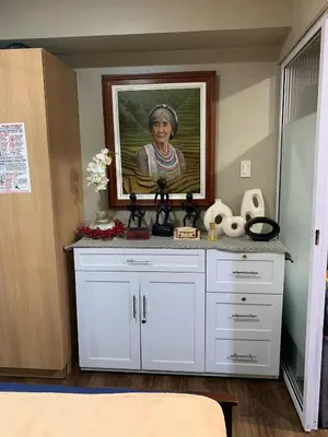 a white dresser with a painting of an older woman at Azure Urban Resort - Rio Tower in Manila