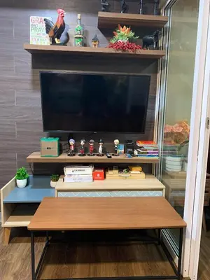 a entertainment center with a flat screen tv and a table at Azure Urban Resort - Rio Tower in Manila