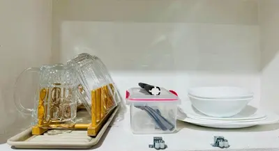 a kitchen counter with a blender and plates and a bowl at Peaceful and cozy unit in Manila