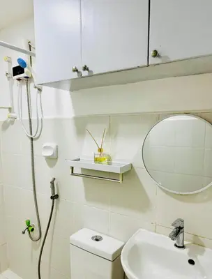 a bathroom with a sink and a mirror and a toilet at Peaceful and cozy unit in Manila