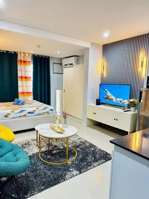 a hotel room with a bed and a living room at Peaceful and cozy unit in Manila