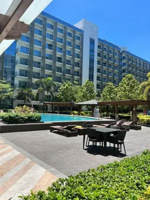 a patio with a table and chairs in front of a building at JOVYNOEL Condominium Unit Rental in Manila