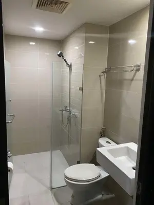 a bathroom with a shower and a toilet and a sink at JOVYNOEL Condominium Unit Rental in Manila
