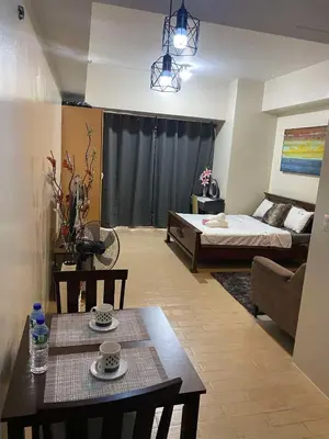 a living room with a bed and a table at JOVYNOEL Condominium Unit Rental in Manila