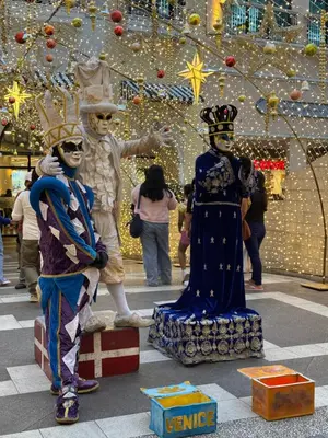 two people in costumes standing next to a statue in a mall at 1BR Condo Near Venice Canal & BGC with Great View - 20k in Manila