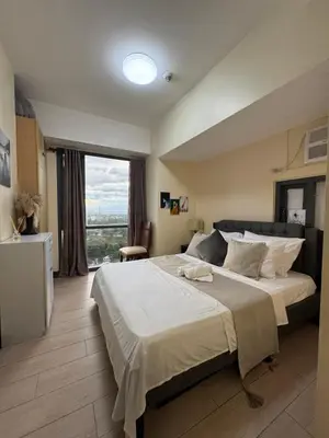 a bedroom with a large bed and a large window at 1BR Condo Near Venice Canal & BGC with Great View - 20k in Manila