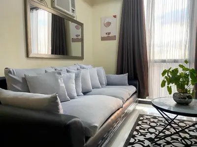 a living room with a couch and a table at 1BR Condo Near Venice Canal & BGC with Great View - 20k in Manila