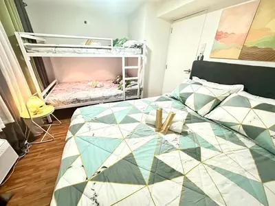 a bedroom with a bed and a bunk bed at HiYara Loft - GA Tower 2, beside MRT BONI Station in Manila