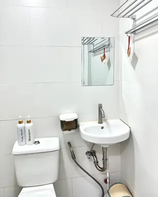 a white bathroom with a toilet and a sink at HiYara Loft - GA Tower 2, beside MRT BONI Station in Manila