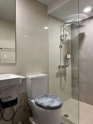 a bathroom with a shower and a toilet and a sink at New 1BR Condo Near Venice Canal & BGC with Balcony - 7e in Manila