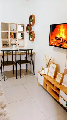 a living room with a table and a tv on a wall at Shore Residences Moa Area Pasay City in Manila