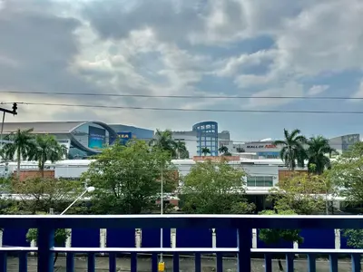 a view of a city with a blue fence and buildings at Staycation Near Moa by Jen in Manila