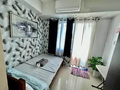 a bedroom with a bed with a teddy bear on it at Staycation Near Moa by Jen in Manila