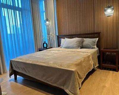 a bedroom with a large bed with blue curtains at Cozy, Spacious 1 Bedroom Condo, reach St Lukes BGC by foot in Manila