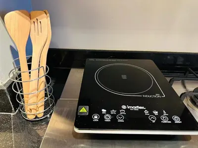 a tablet computer sitting on a counter next to wooden utensils at Cozy, Spacious 1 Bedroom Condo, reach St Lukes BGC by foot in Manila