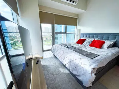 a bedroom with a large bed with red pillows at Luxury 2BR Corner near Solaire & Okada II Sunset in Manila