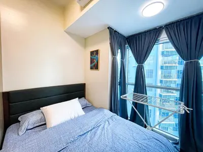 a bedroom with a bed and a large window at Luxury 2BR Corner near Solaire & Okada II Sunset in Manila