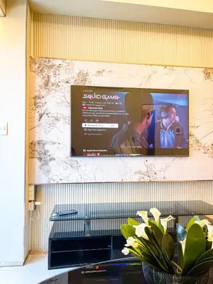 a television hanging on a wall with a picture on it at Ultra Luxury 1BR near Solaire & Okada in Manila