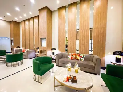 a living room with a couch and green chairs at Ultra Luxury 1BR near Solaire & Okada in Manila