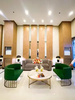 a living room with green chairs and a table at Ultra Luxury 1BR near Solaire & Okada in Manila
