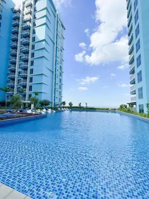 a swimming pool in the middle of two tall buildings at Ultra Luxury 1BR near Solaire & Okada in Manila