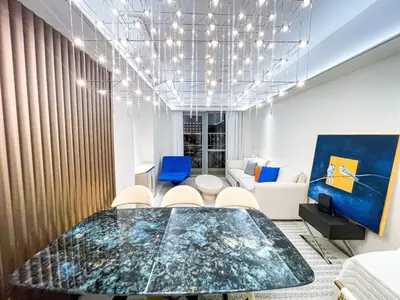 a dining room with a glass table and blue chairs at Luxury 2BR Penthouse across City of Dreams in Manila