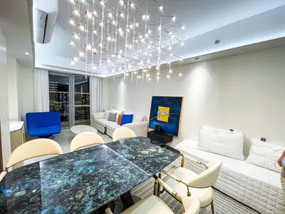 a living room with a table and chairs and a couch at Luxury 2BR Penthouse across City of Dreams in Manila