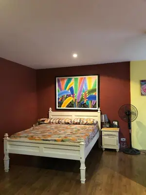 a bed in a room with a painting on the wall at Our home is your castle in Caong