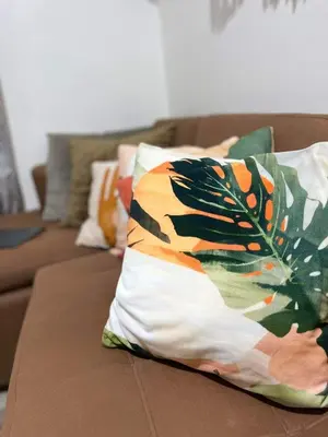 a couch with a pillow with a feather on it at Staycation in Mandaluyong in Manila