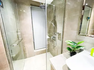 a bathroom with a shower with a glass door at Luxury 4BR Penthouse across City of Dreams in Manila