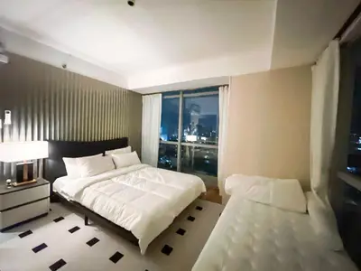 a bedroom with a large white bed and a window at Luxury 4BR Penthouse across City of Dreams in Manila