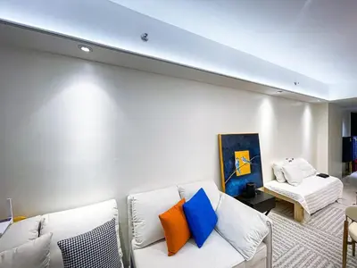 a living room with a white couch with colorful pillows at Luxury 4BR Penthouse across City of Dreams in Manila