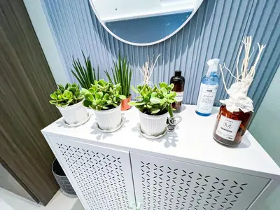 a table with three potted plants and a mirror at Luxury Penthouse across City of Dreams II 7pax in Manila