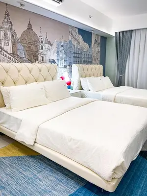 two beds in a room with a mural at Luxury Penthouse near Solaire, City of Dreams in Manila
