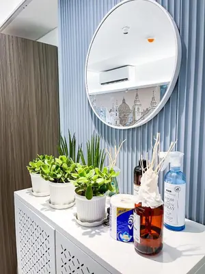 a dressing table with three plants and a mirror at Luxury Penthouse near Solaire, City of Dreams in Manila