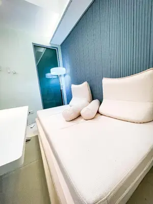 a bed with two pillows on it in a room at Luxury Penthouse near Solaire, City of Dreams in Manila