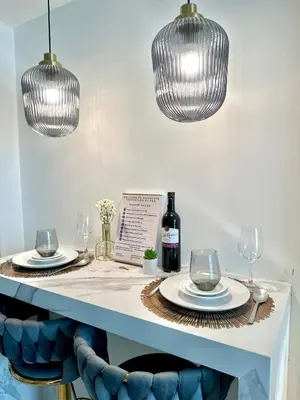 a table with plates and wine glasses and lights at Cityscape Staycation by H&B in Manila