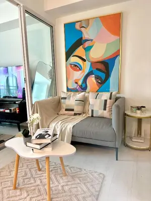 a living room with a couch and a painting at Cityscape Staycation by H&B in Manila